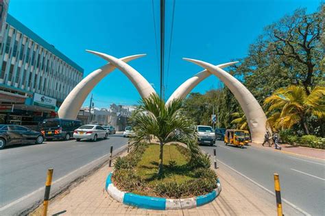 Cars pass on asphalt of Mombasa under pair of crossing horns : 2 Day Mombasa Heavenly Beaches Itinerary